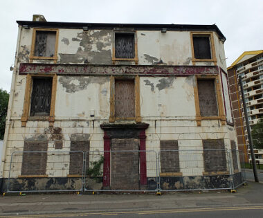 the front of a collapsing fenced off derelict abandoned pub building in wakefield england awaiting demolition