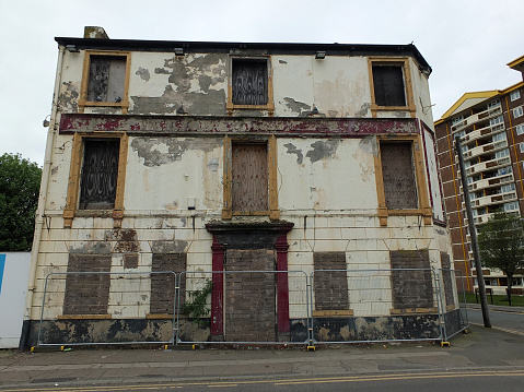 the front of a collapsing fenced off derelict abandoned pub building in wakefield england awaiting demolition